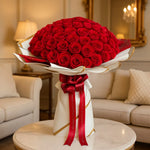 Load image into Gallery viewer, Bouquet of red roses with a red ribbon on a table in a living room setting
