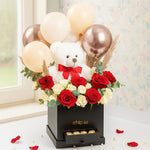 Load image into Gallery viewer, Teddy bear with red bow surrounded by flowers and balloons on a black box, with &#39;ship aa&#39; branding.
