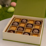 Load image into Gallery viewer, Open box of chocolates with a cat in the background
