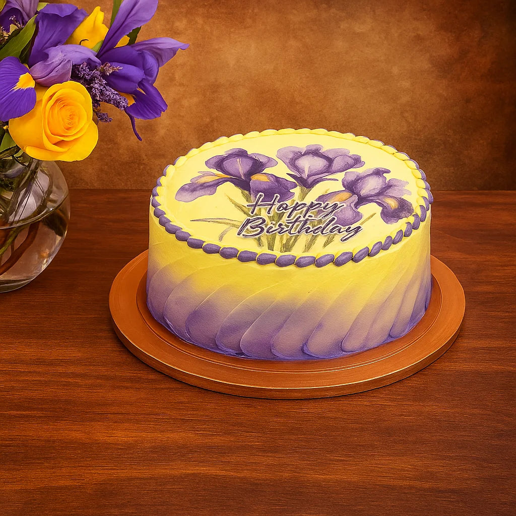 Birthday cake with purple and yellow flowers and 'Happy Birthday' text on a wooden table.