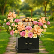 Bouquet of flowers with a box of chocolates on a green outdoor background