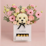 Load image into Gallery viewer, Floral arrangement with a white dog toy and chocolates in a box on a pink background
