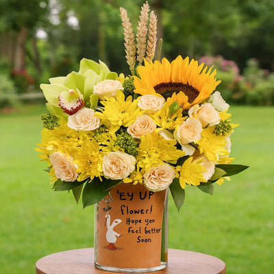 Bouquet of flowers with a message card in a vase on a green background