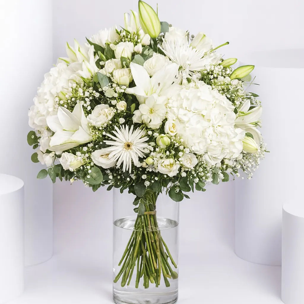 Bouquet of white flowers in a clear vase on a white background