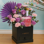 Load image into Gallery viewer, Floral arrangement with pink and purple flowers in a black box on a wooden floor.