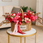 Load image into Gallery viewer, Floral arrangement in a woven basket on a marble table with a blurred background
