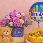 Load image into Gallery viewer, Birthday arrangement with flowers, teddy bear, cake, and balloon on a pink background
