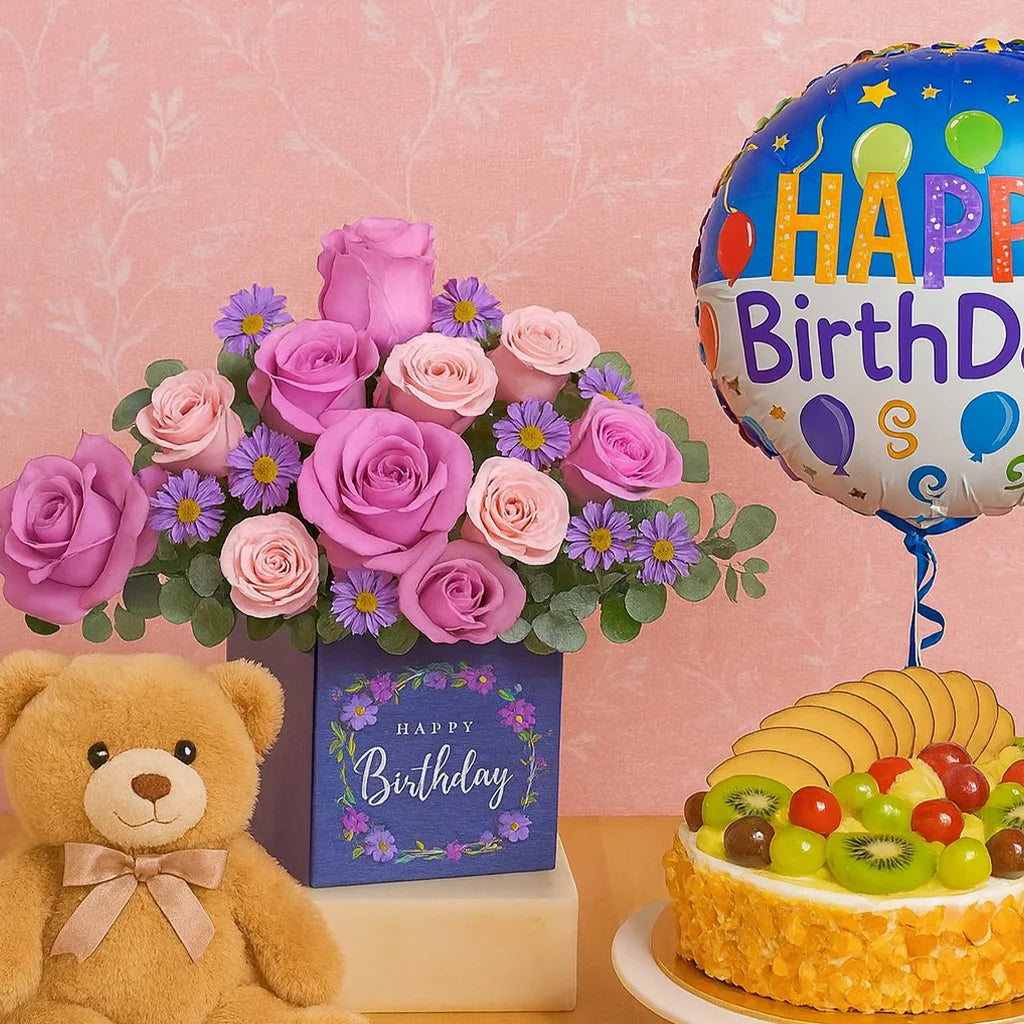 Birthday arrangement with flowers, teddy bear, cake, and balloon on a pink background