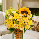 Load image into Gallery viewer, Bouquet of yellow and green flowers in a vase with a message in a living room setting.

