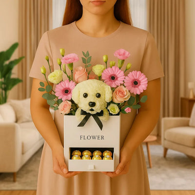 Person holding a box of flowers with a dog-shaped center in a living room setting