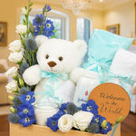Load image into Gallery viewer, Greeting set with teddy bear, flowers, and &#39;Welcome to the World&#39; sign in a decorative box.
