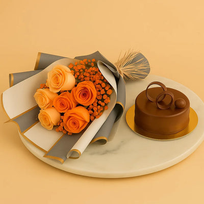 Bouquet of orange roses and decorative flowers with a small chocolate cake on a beige background
