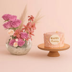 Load image into Gallery viewer, Pink birthday cake with &#39;Happy Birthday&#39; message and a vase of pink flowers on a pink background
